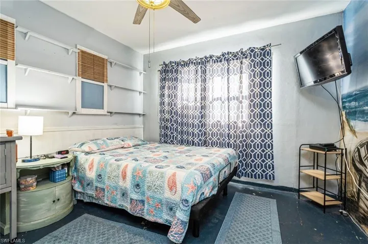 Bedroom with ceiling fan and concrete floors