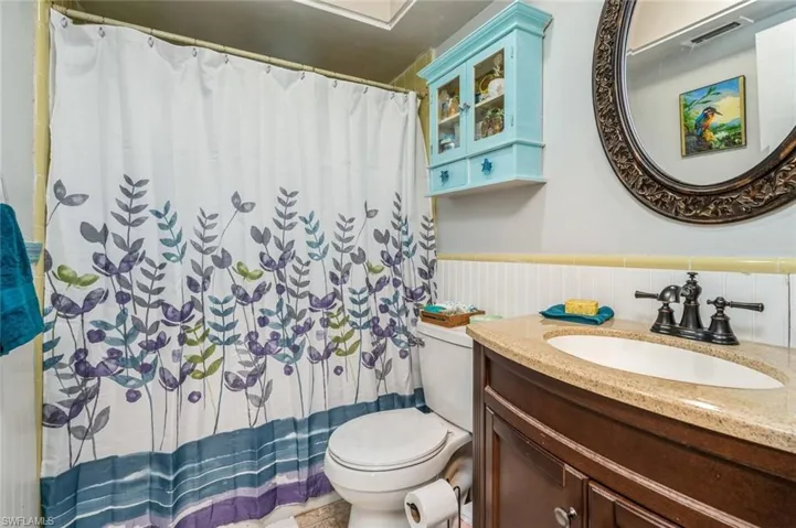 Bathroom with vanity, backsplash, and toilet
