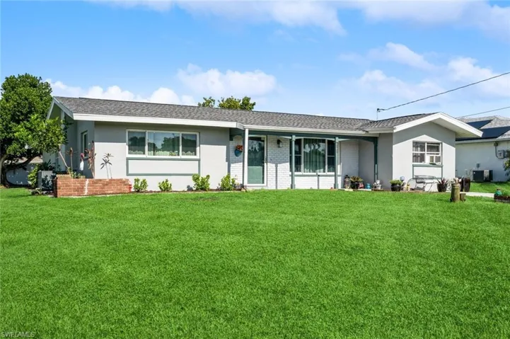 Single story home featuring cooling unit and a front yard
