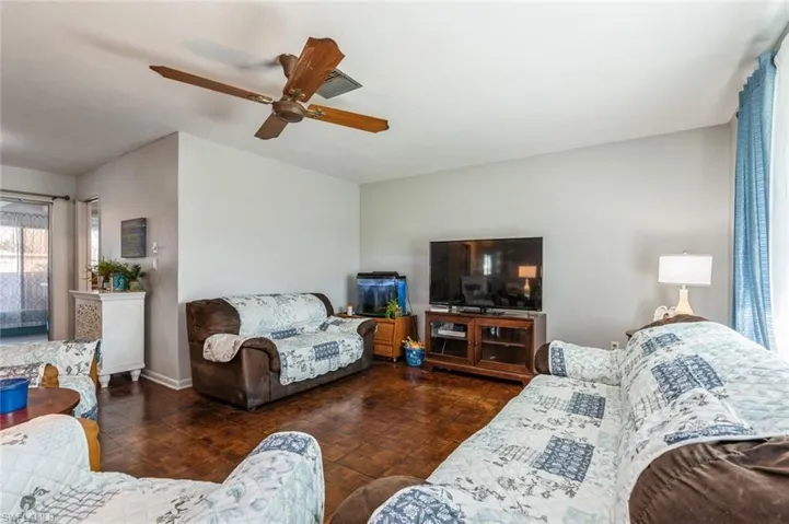 Living room featuring ceiling fan and dark parquet floors