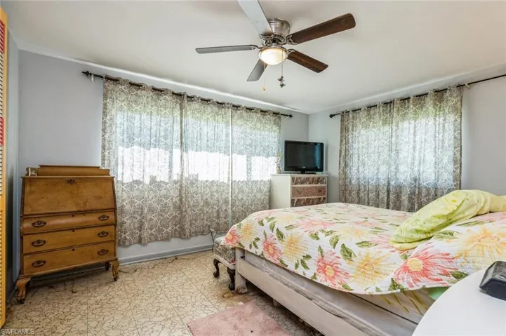 Bedroom with light tile patterned floors and ceiling fan