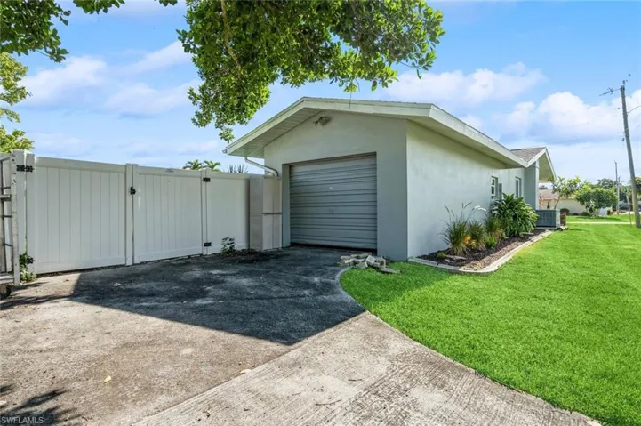 Garage featuring cooling unit and a lawn