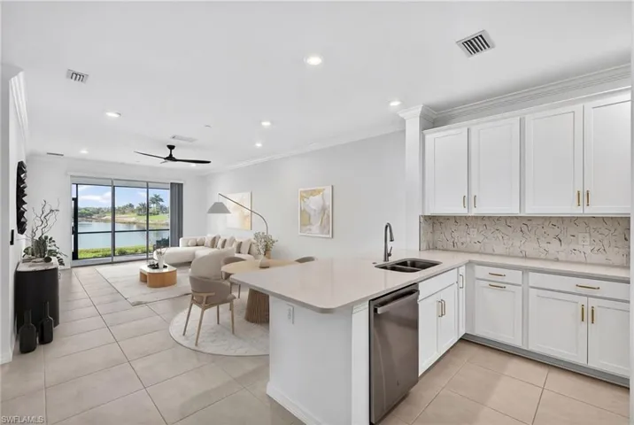 Kitchen with a peninsula, white cabinetry, ceiling fan, stainless steel dishwasher, and recessed lighting