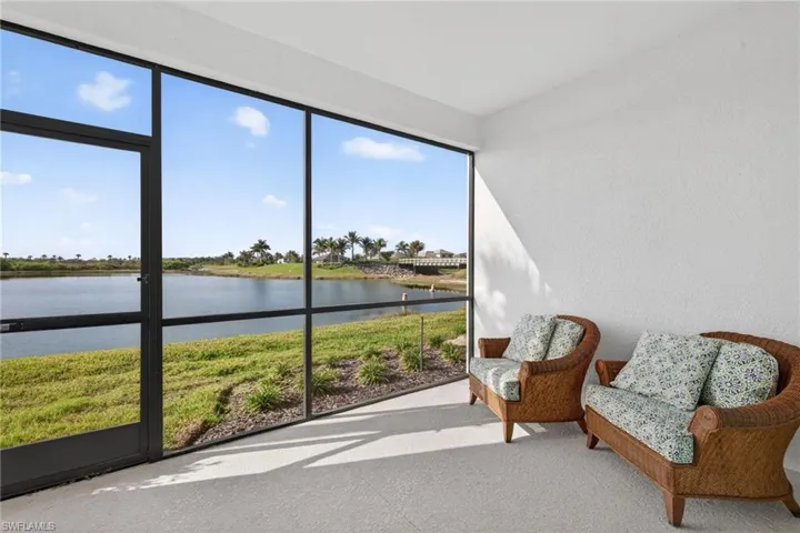 Sunroom / solarium with a water view and a textured wall