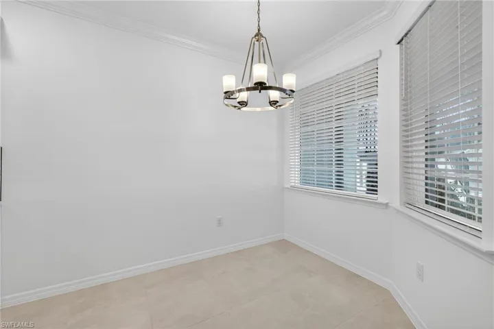Unfurnished dining area with ornamental molding and suspended lighting
