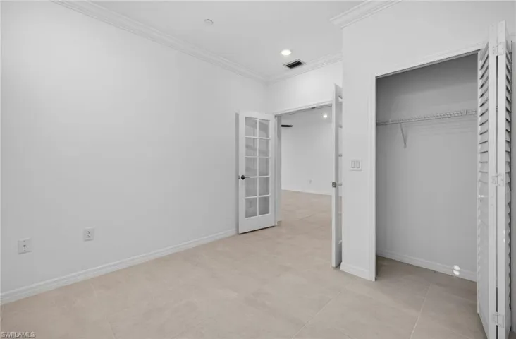 Unfurnished bedroom featuring ornamental molding, a closet, recessed lighting, and french doors
