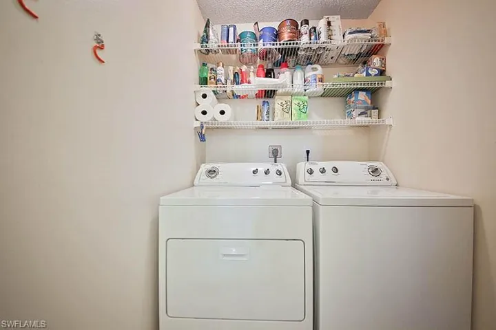 Laundry area with washing machine and clothes dryer and a textured ceiling
