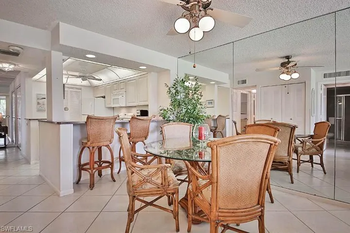 Dining room with a ceiling fan, light tile patterned flooring, and a textured ceiling