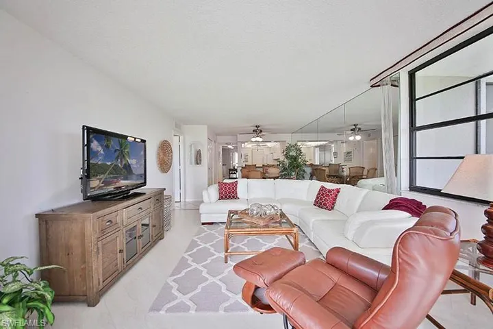 Living area with ceiling fan and light tile patterned flooring