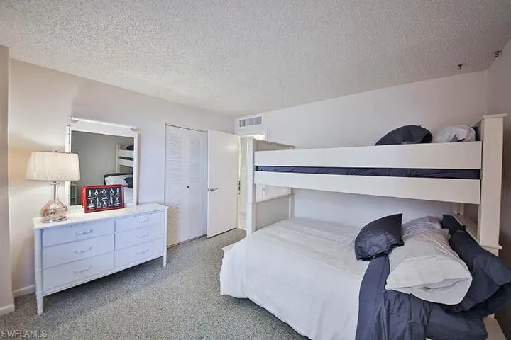 Bedroom featuring carpet flooring, a textured ceiling, and a closet