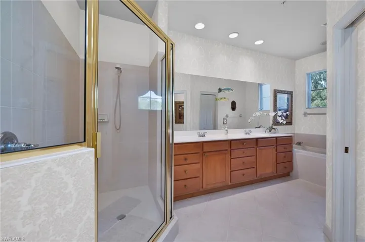 Bathroom featuring tile patterned flooring, vanity, and separate shower and tub