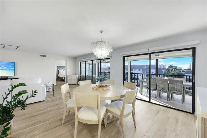 Dining area featuring light wood-style flooring, a chandelier, and a city view