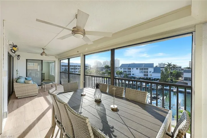 Sunroom / solarium with a water view, wood finished floors, and a textured ceiling