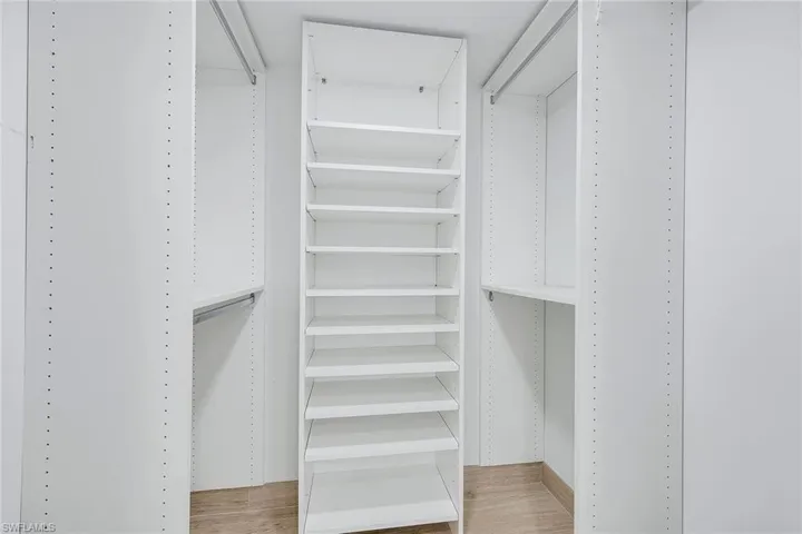 Walk in closet with light wood-style flooring
