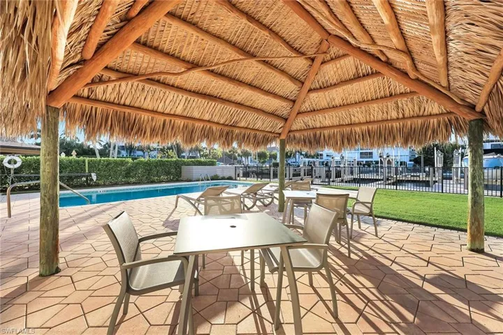 View of patio featuring a community pool and outdoor dining area