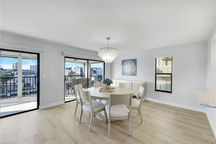 Dining room featuring light wood-style flooring, a chandelier, and plenty of natural light