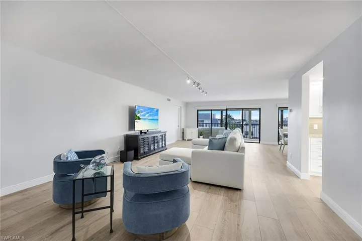 Living room with light wood-style floors and track lighting