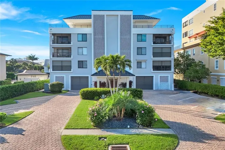 View of apartment building / complex with decorative driveway and a garage