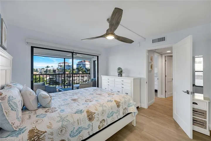 Bedroom featuring access to exterior, light wood-style floors, and a ceiling fan