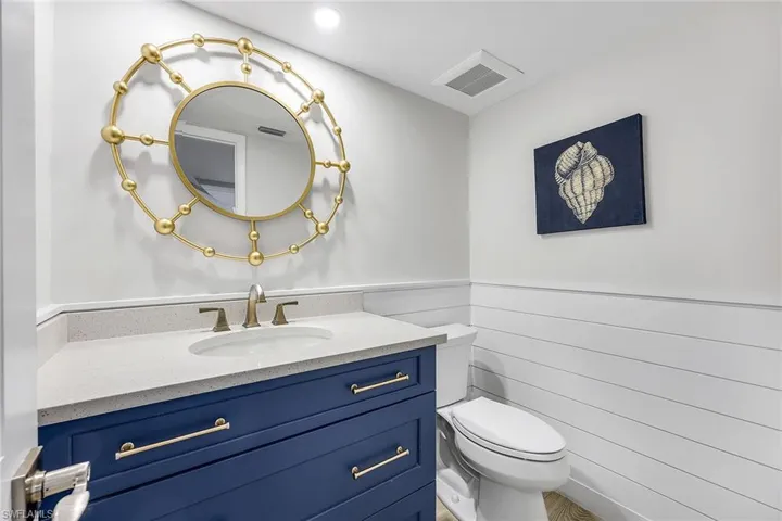 Half bathroom with vanity and wainscoting