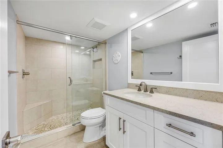 Full bathroom featuring vanity, a shower stall, and recessed lighting
