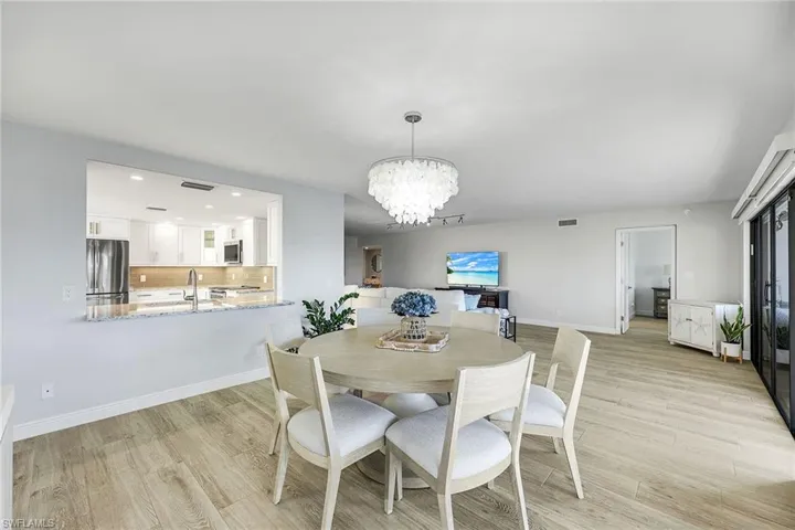 Dining room with a chandelier, light wood finished floors, and recessed lighting