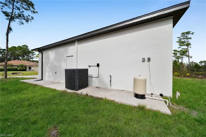 View of side of property featuring stucco siding and a yard