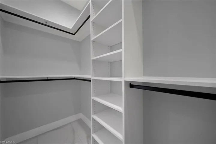 Spacious closet featuring marble finish floors