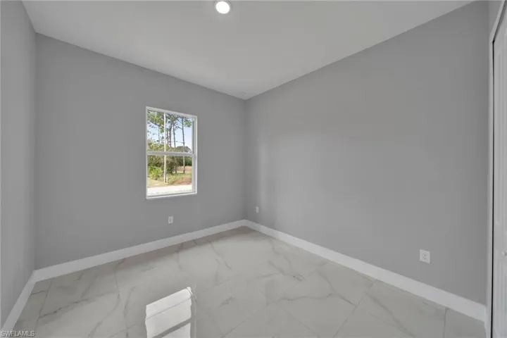 Spare room with light marble finish floors