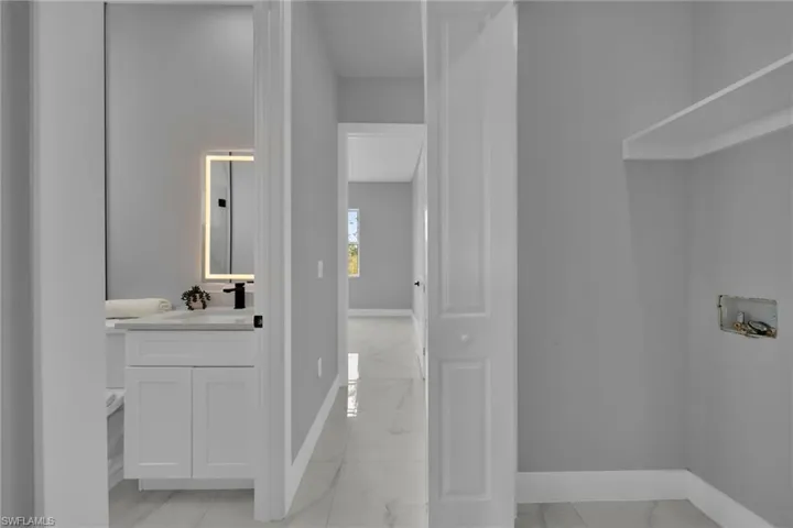 Bathroom with light marble finish floors and vanity