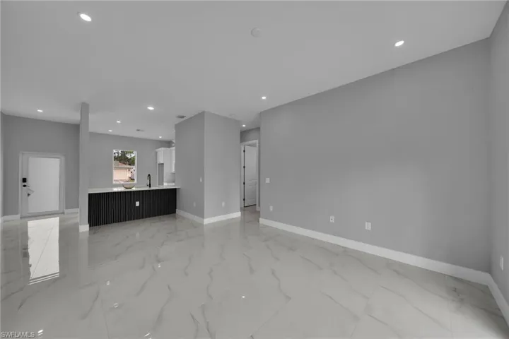 Unfurnished living room with recessed lighting and light marble finish flooring
