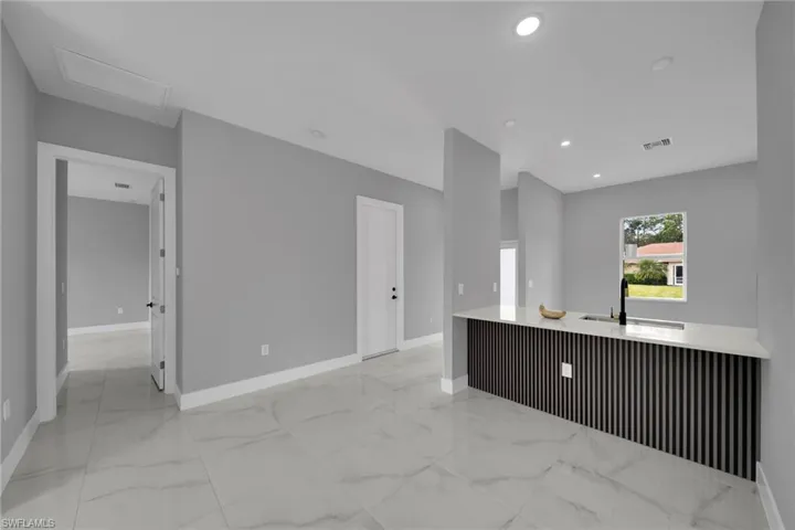 Kitchen featuring light marble finish flooring, light stone countertops, and recessed lighting