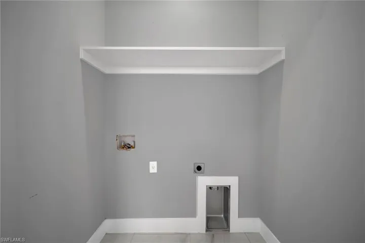 Laundry room with hookup for a washing machine, electric dryer hookup, and tile patterned flooring