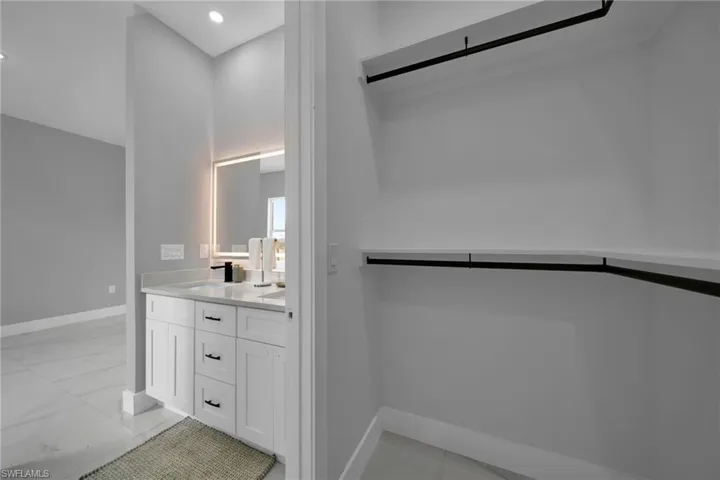 Full bathroom with double vanity and light marble finish flooring