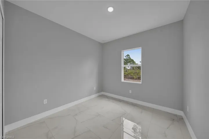 Empty room with light marble finish flooring and baseboards