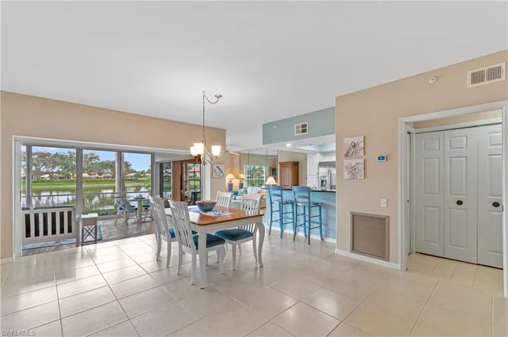 Tiled dining room with a notable chandelier and a water view
