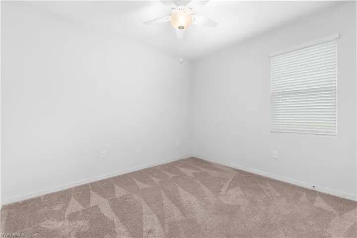 Carpeted bedroom featuring ceiling fan