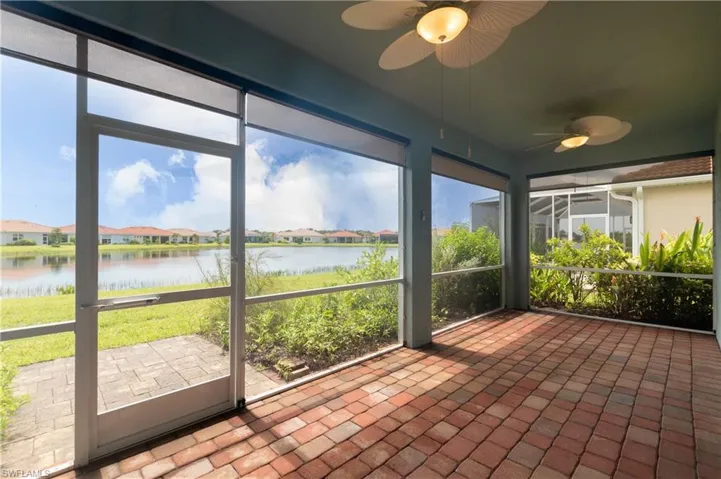 Unfurnished sunroom featuring a water view and ceiling fan