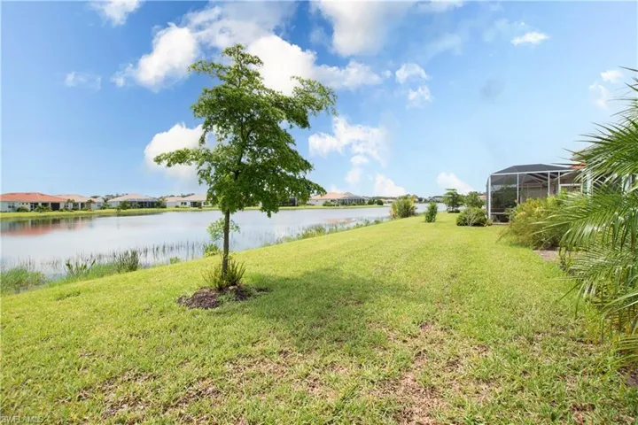 View of yard with a water view and glass enclosure