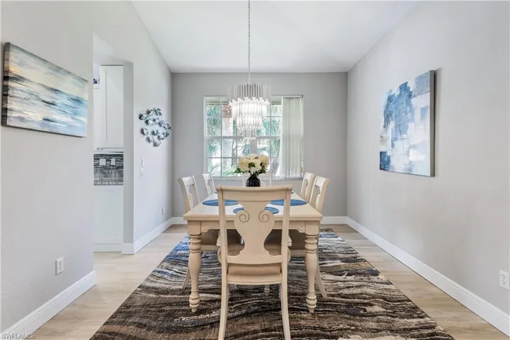 Dining room with light hardwood / wood-style floors and a chandelier
