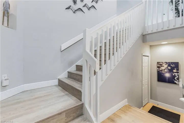 Staircase with light hardwood / wood-style floors