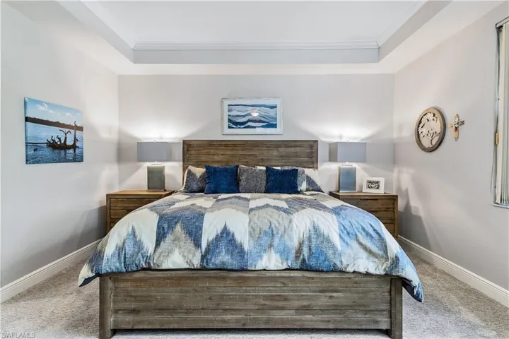 Bedroom with crown molding, a raised ceiling, and carpet floors