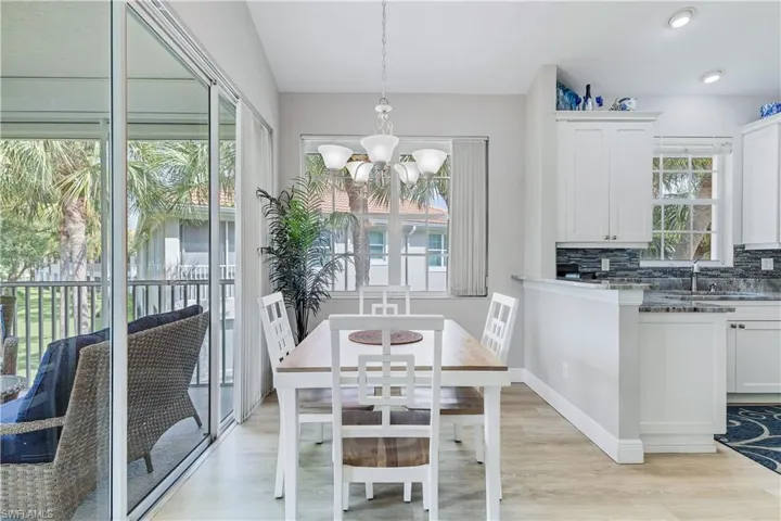 Dining room featuring light hardwood / wood-style floors, sink, and an inviting chandelier