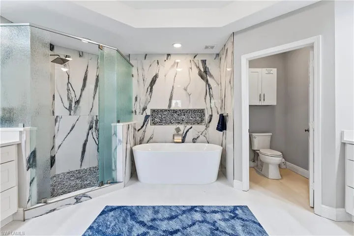 Bathroom with tile floors, walk in shower, toilet, and vanity