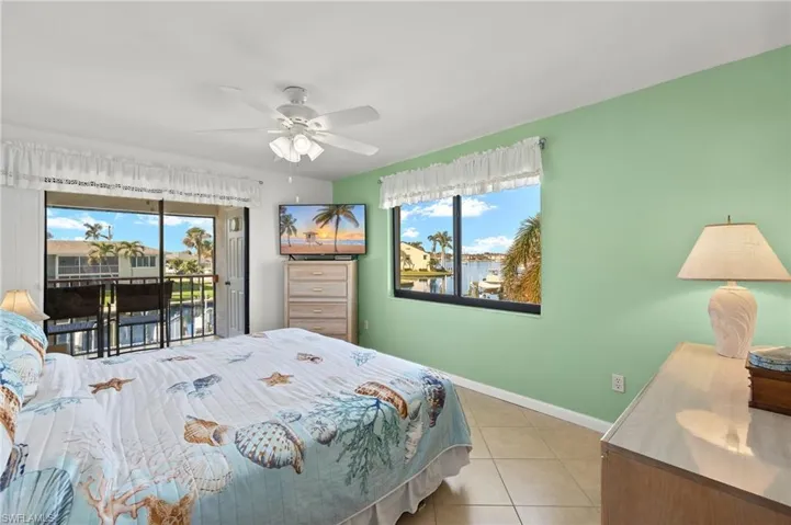 Tiled bedroom featuring access to outside and ceiling fan