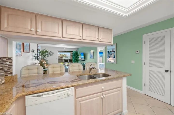 Kitchen featuring kitchen peninsula, white dishwasher, and light brown cabinets