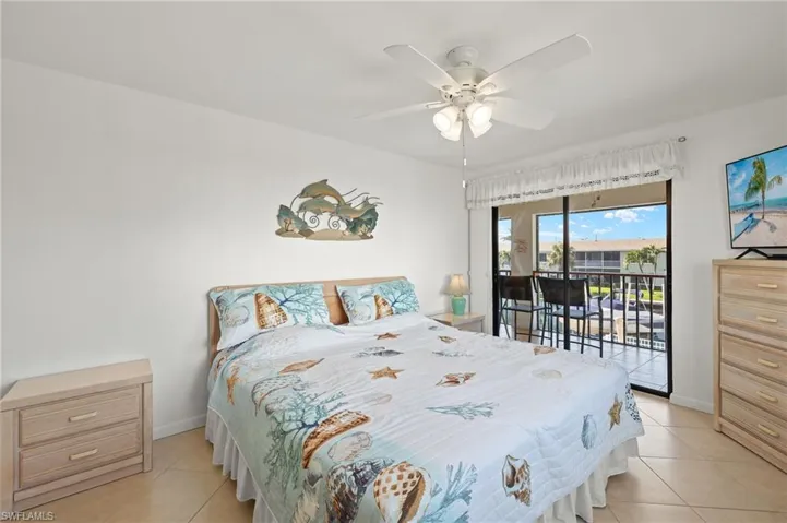 Tiled bedroom featuring access to outside and ceiling fan