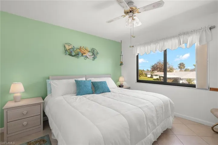 Bedroom with light tile patterned floors and ceiling fan
