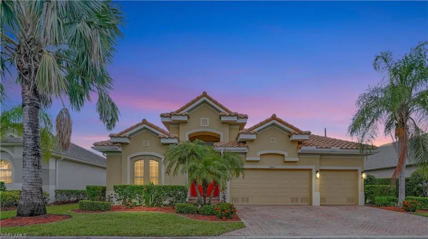 Mediterranean / spanish house with a garage and a lawn