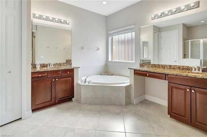 Bathroom with vanity, tile patterned flooring, and separate shower and tub